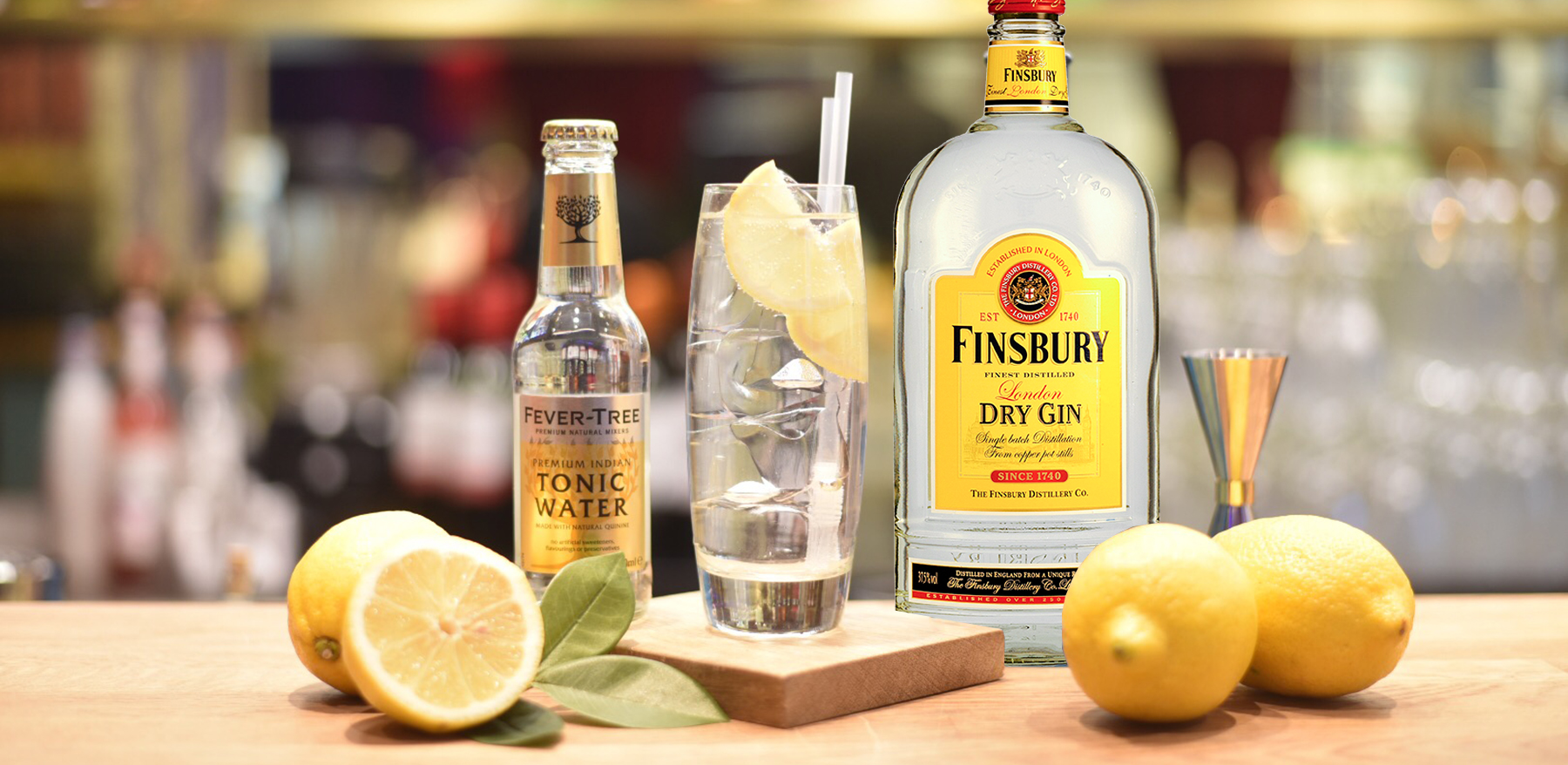 en flaska gin med gin och tonic drink och citroner