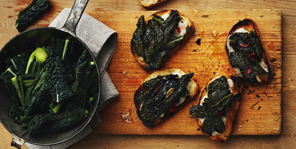 bruschetta som ligger på en skärbräda toppad med grönsaker