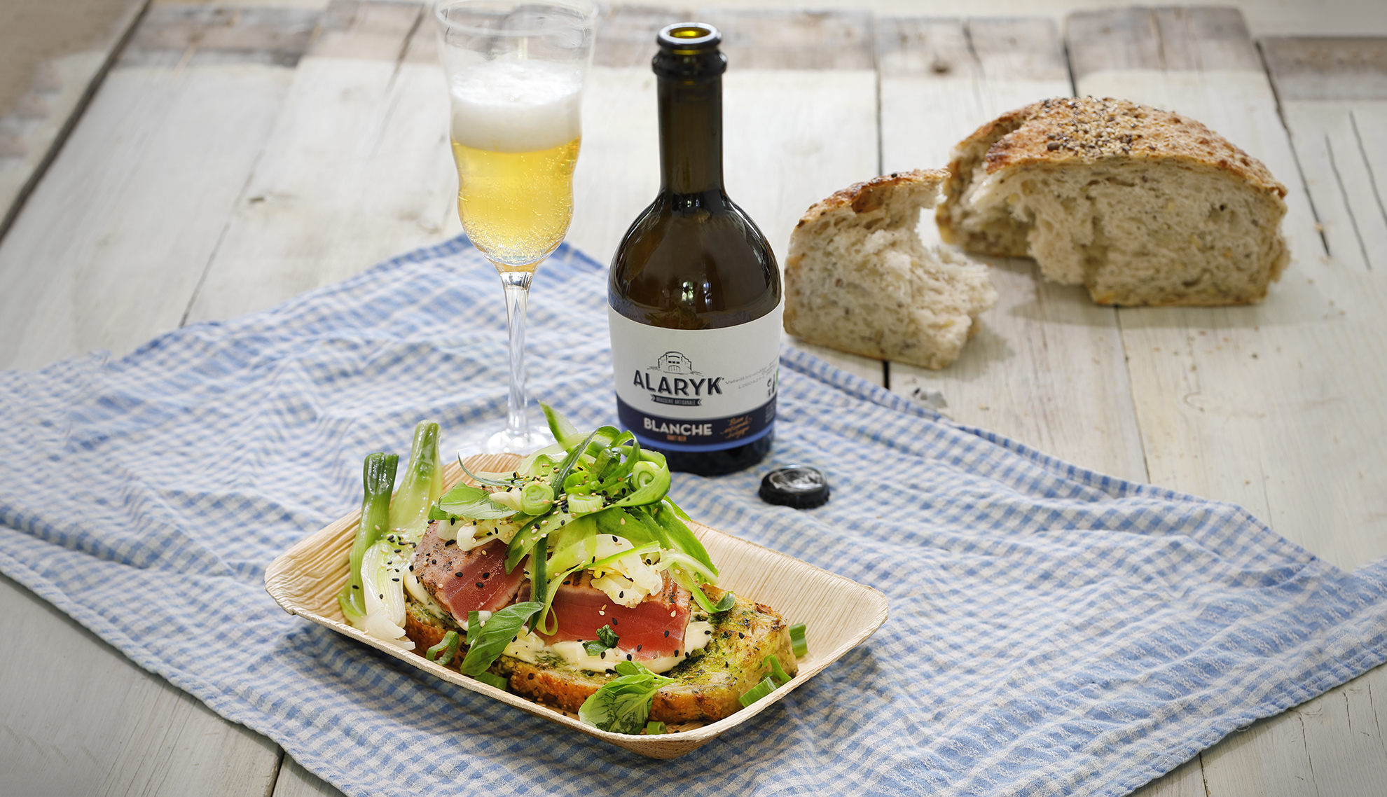 en tonfiskmacka med ett glas öl