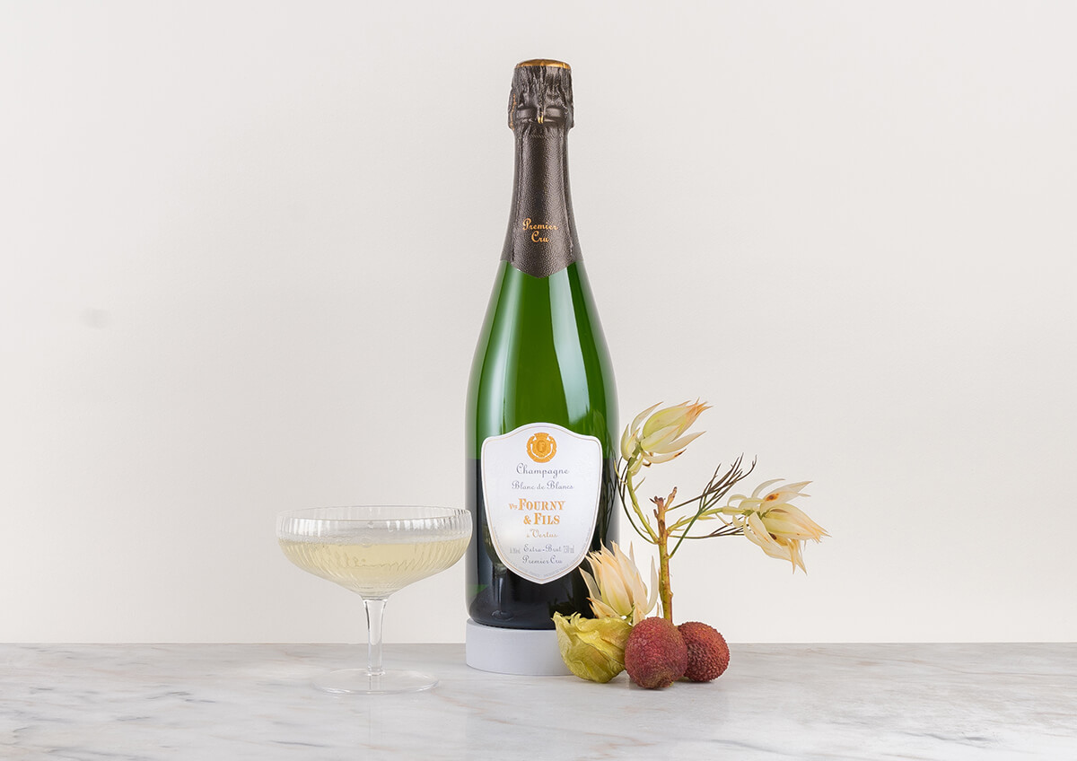 en flaska champagne med glas och ett litet träd