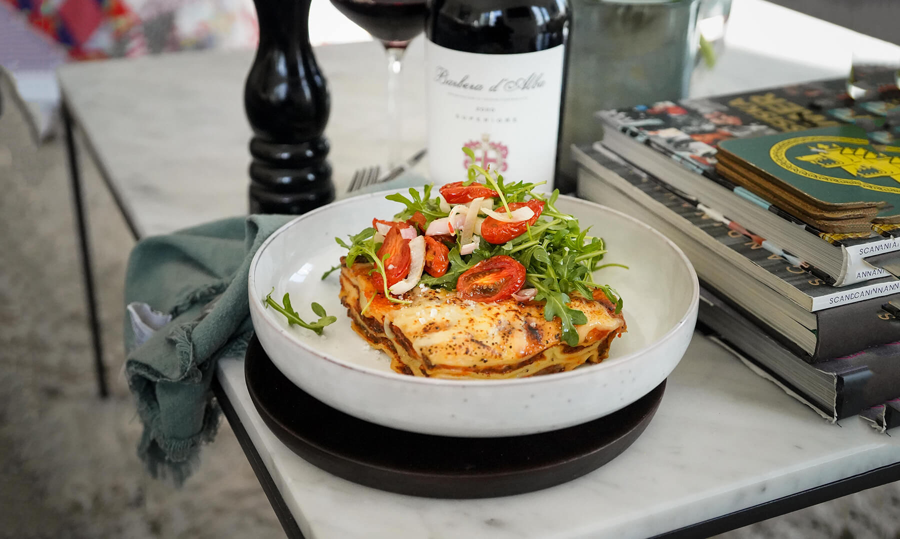 lasagne i pastatallrik tillsammans med vin