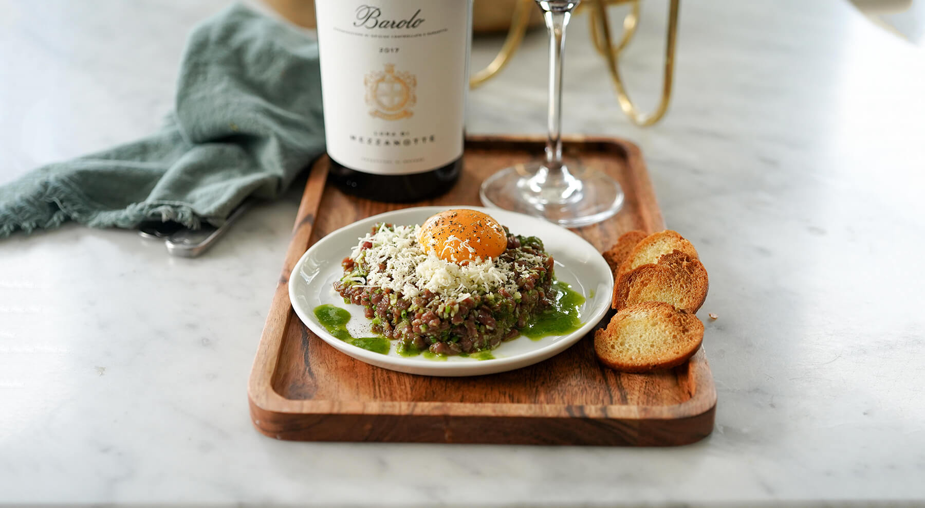 en råbiff på tallrik och en träbricka