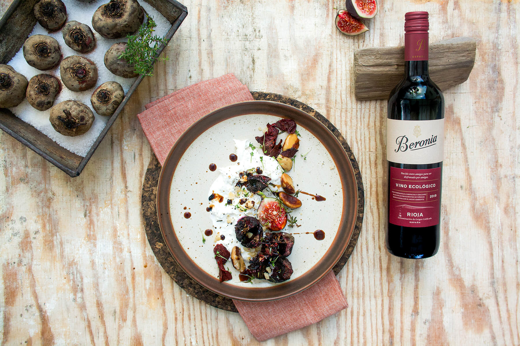 rödbeta med ost burrata och vinflaska med tallrik och plåt