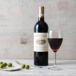 en flaska hartenberg vin med rött vin i glaset