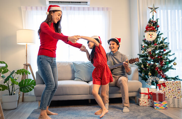 en mamma som dansar med sitt bar och pappa spelar gitarr
