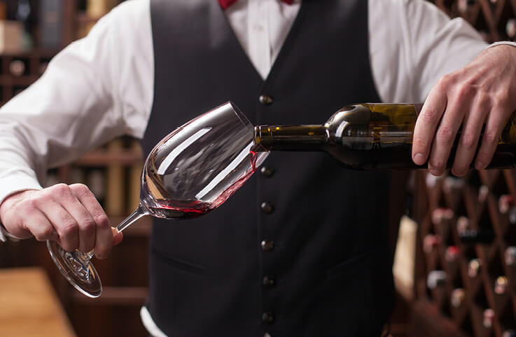 en somelier som serverar vin