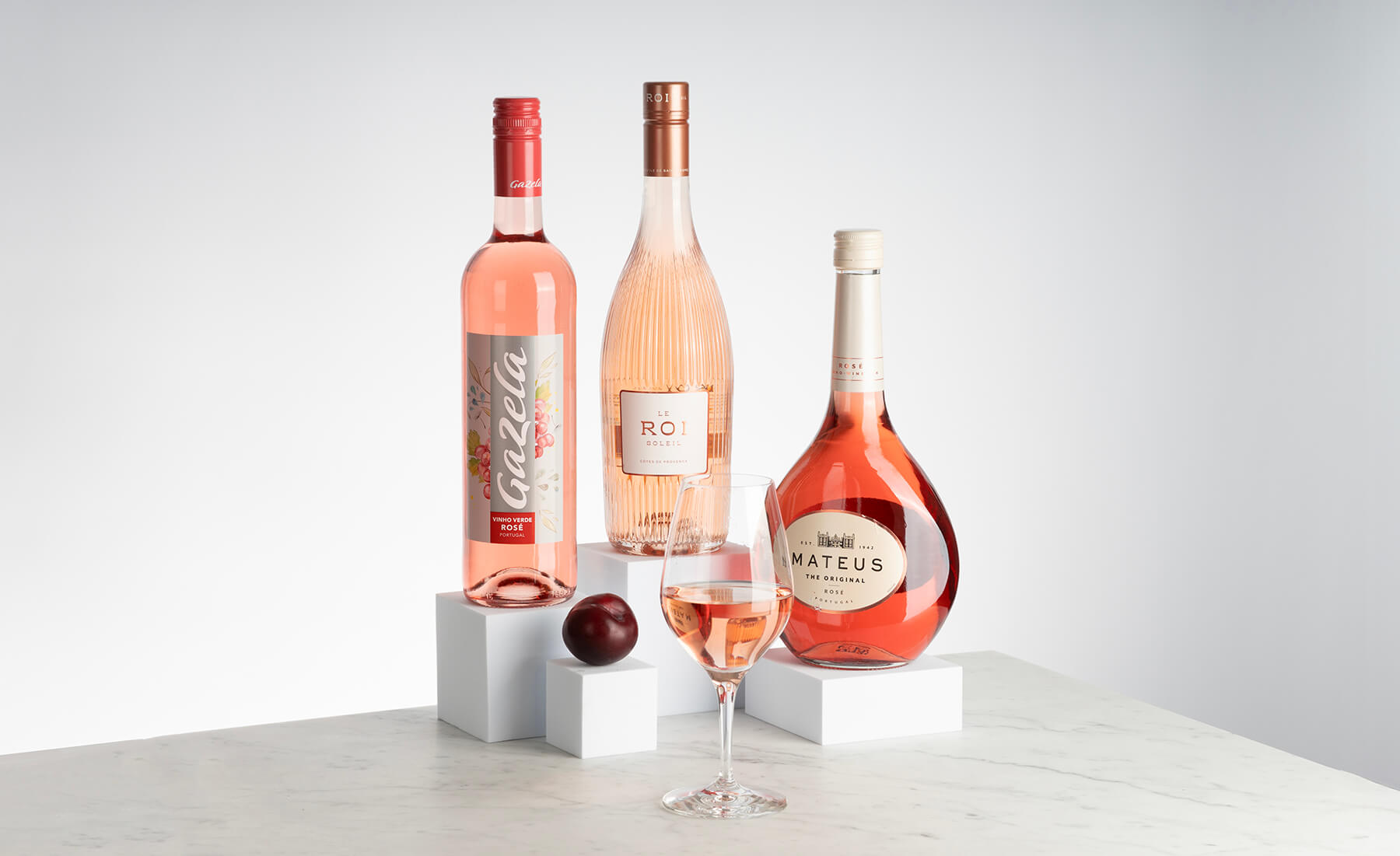 tre flaskor rose som står på ett bord