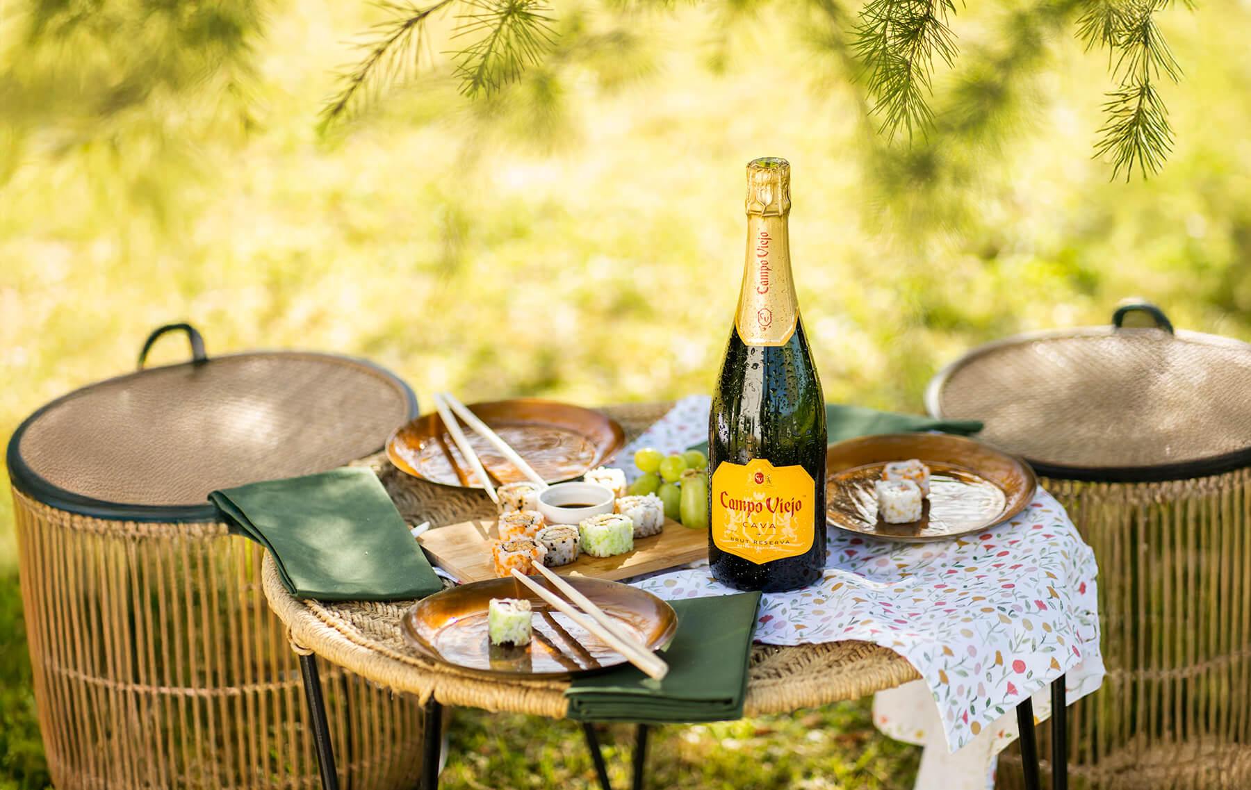 en trädgård med stolar och bord solen som lyser igenom trädet med vin